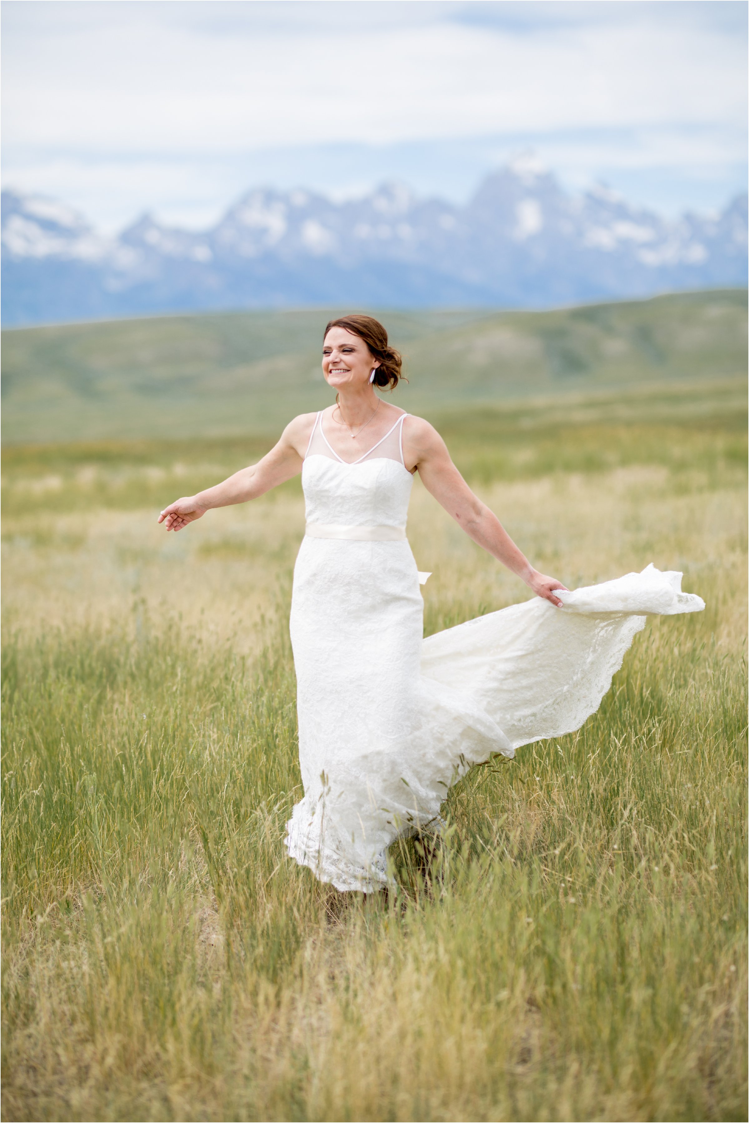 bride spins twirling her dress in front of the tetons