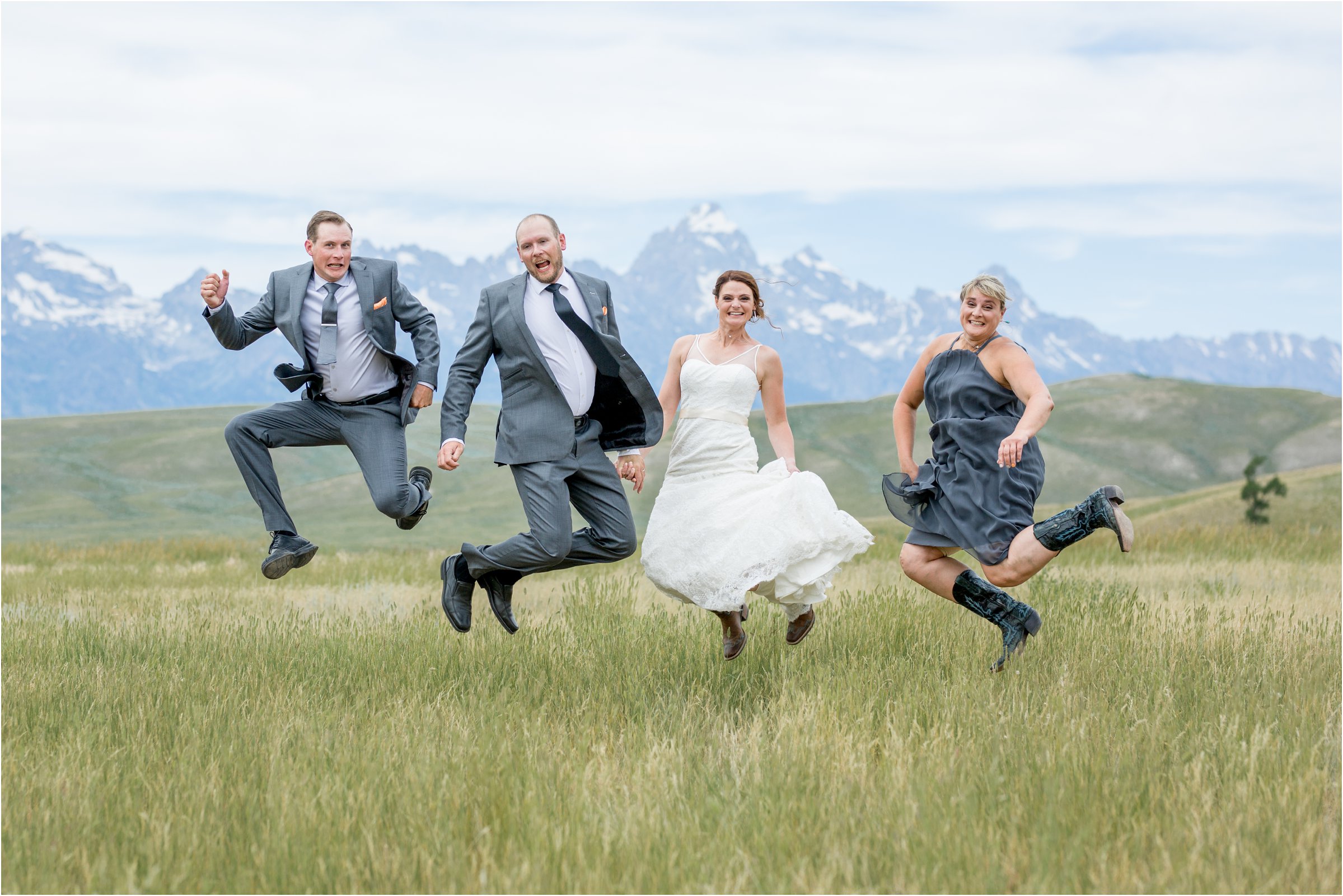 bride, groom, maid of honor, and best man all jump in front of the tetons