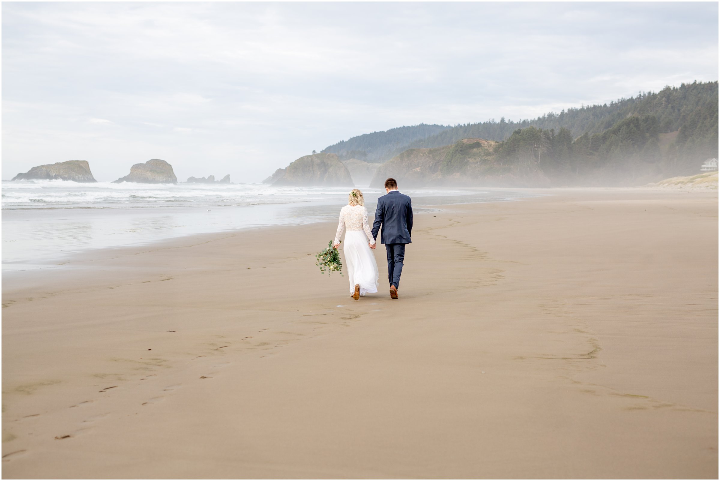 bride and groom walking down cannon beach together after their elopement