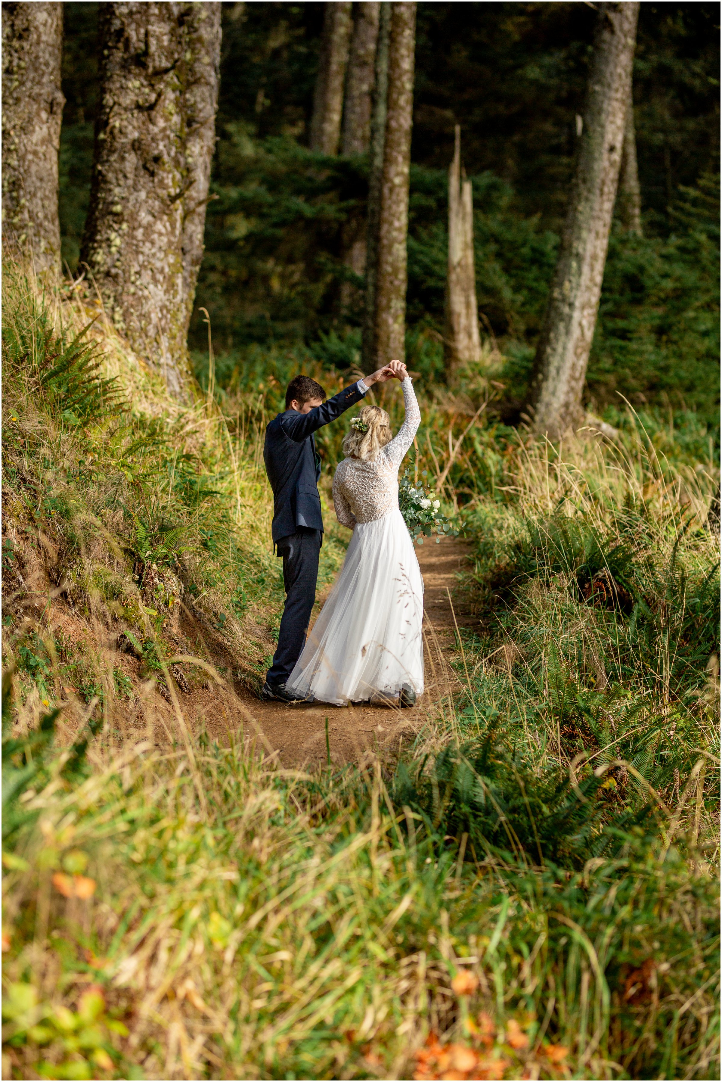 bride and groom dance together on a path in ecola state park with trees and green surrounding them