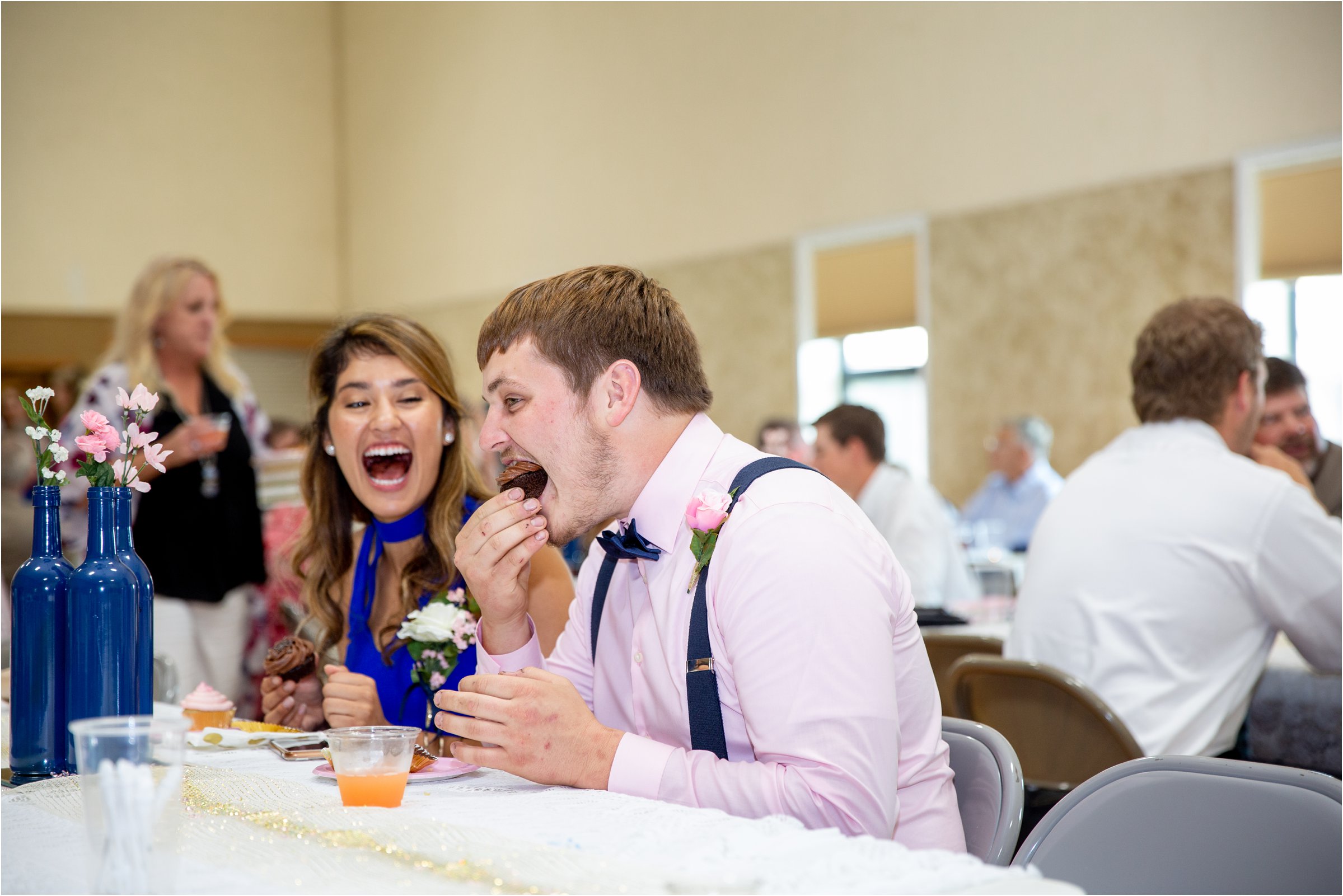 bride's brother eats a cupcake at his sister's wedding reception at holdrege trinity church