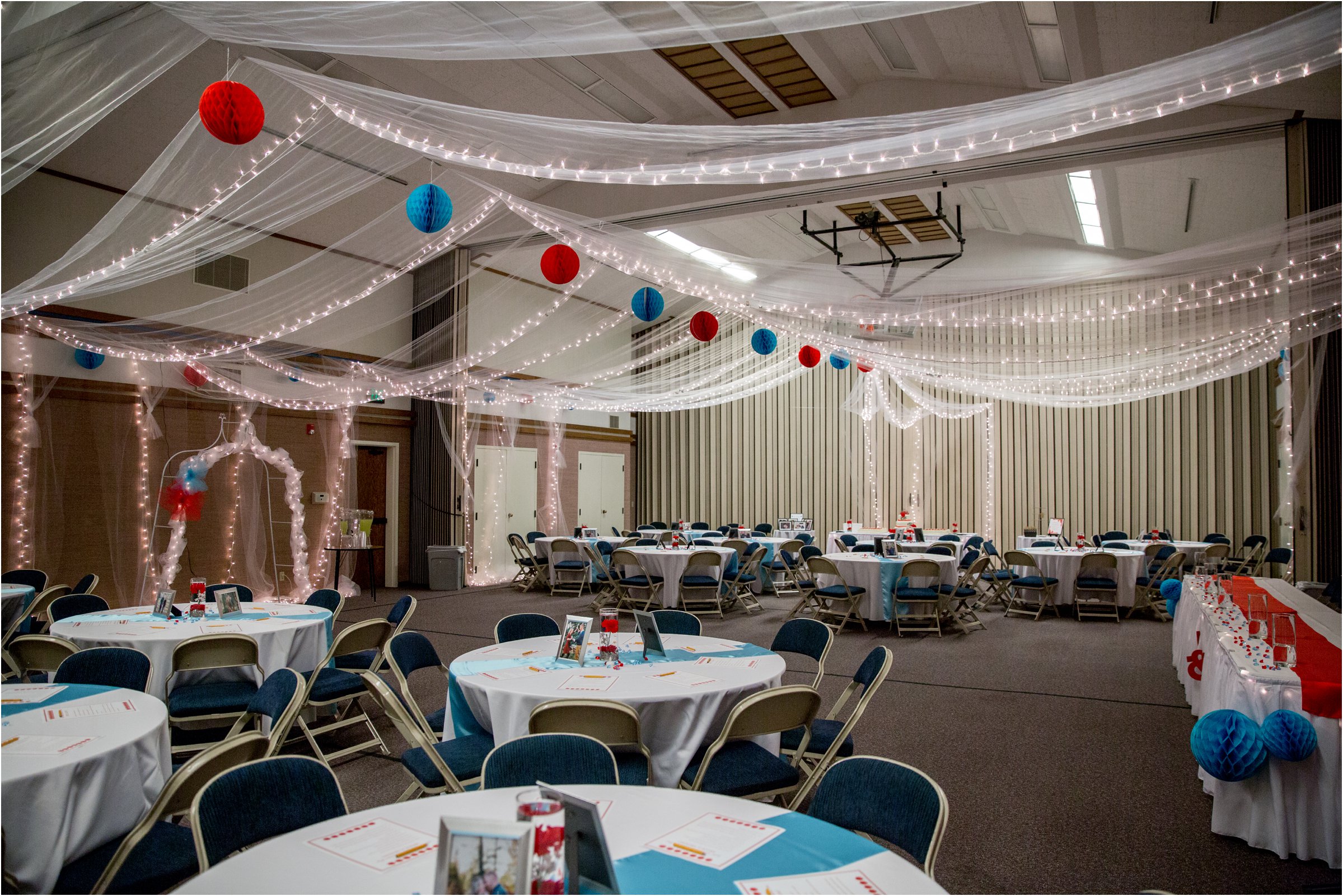 room set up for a wedding reception with red and blue accents