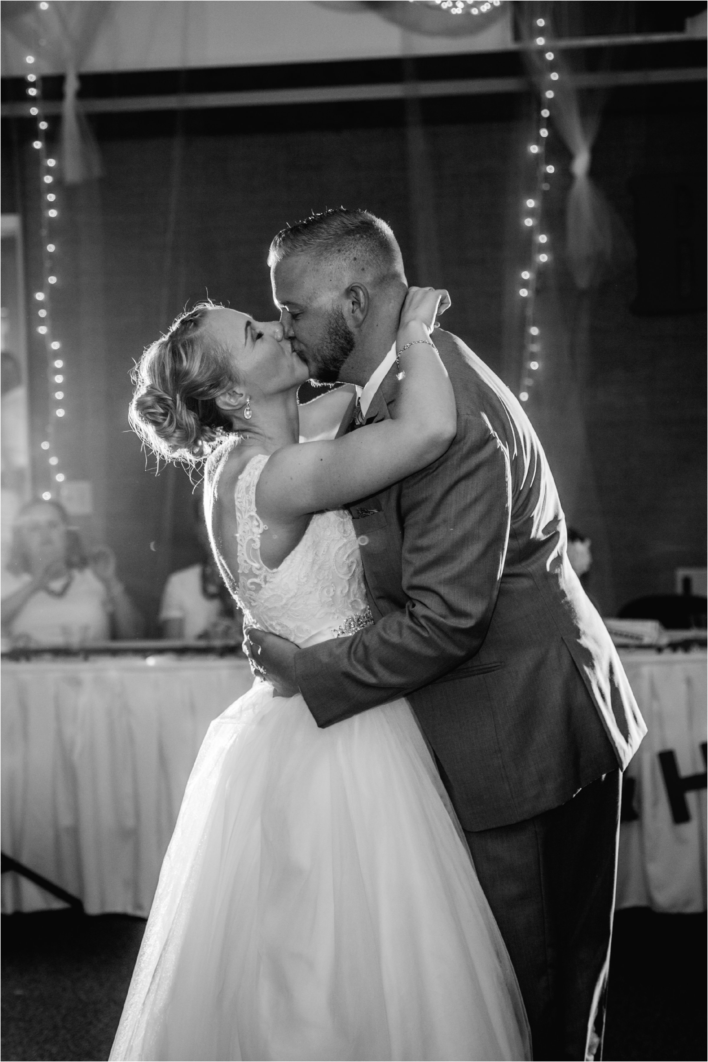 black and white photo of bride and groom kissing at the end of their first dance at their wedding reception