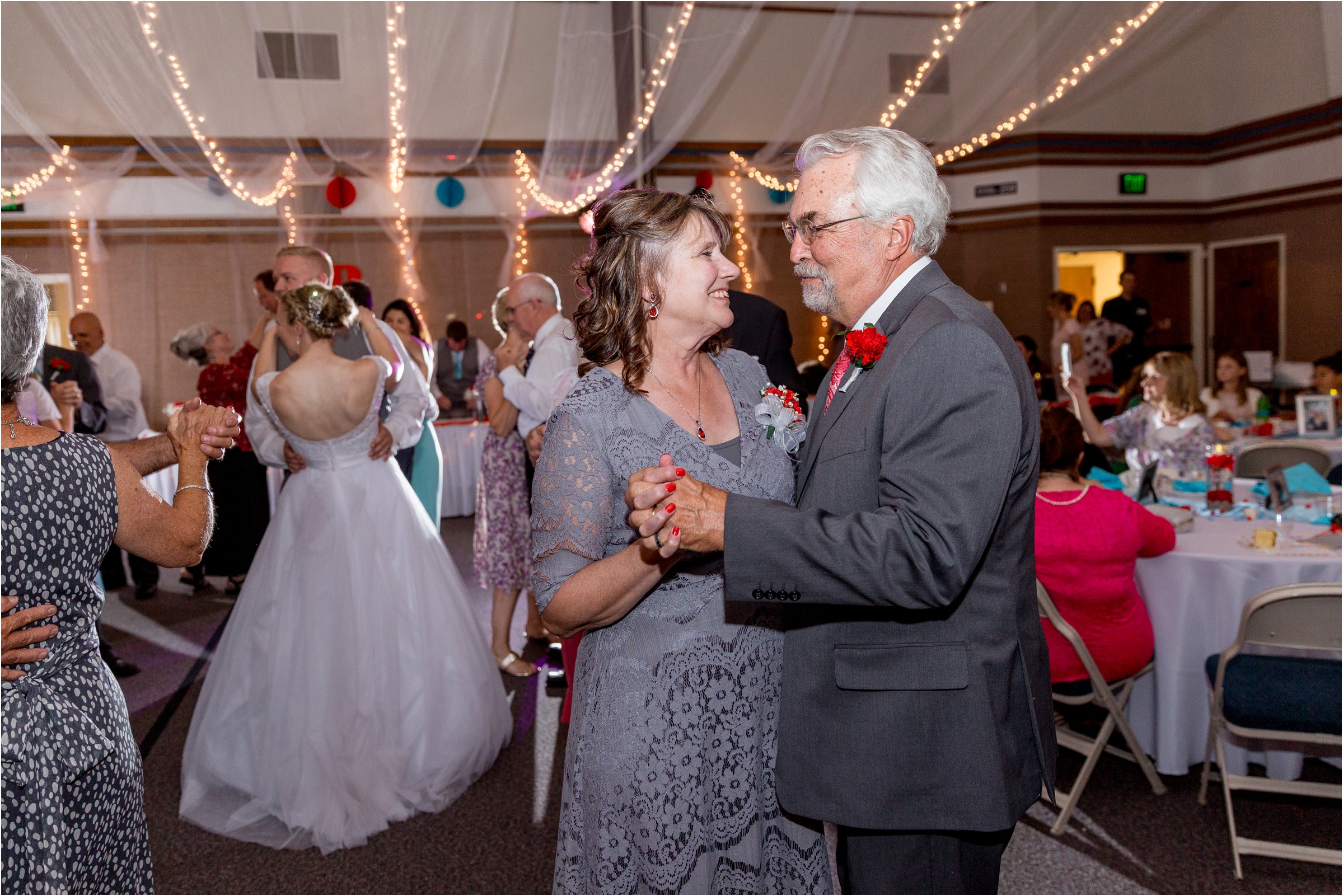 bride's parents dance together at their daughter's wedding reception