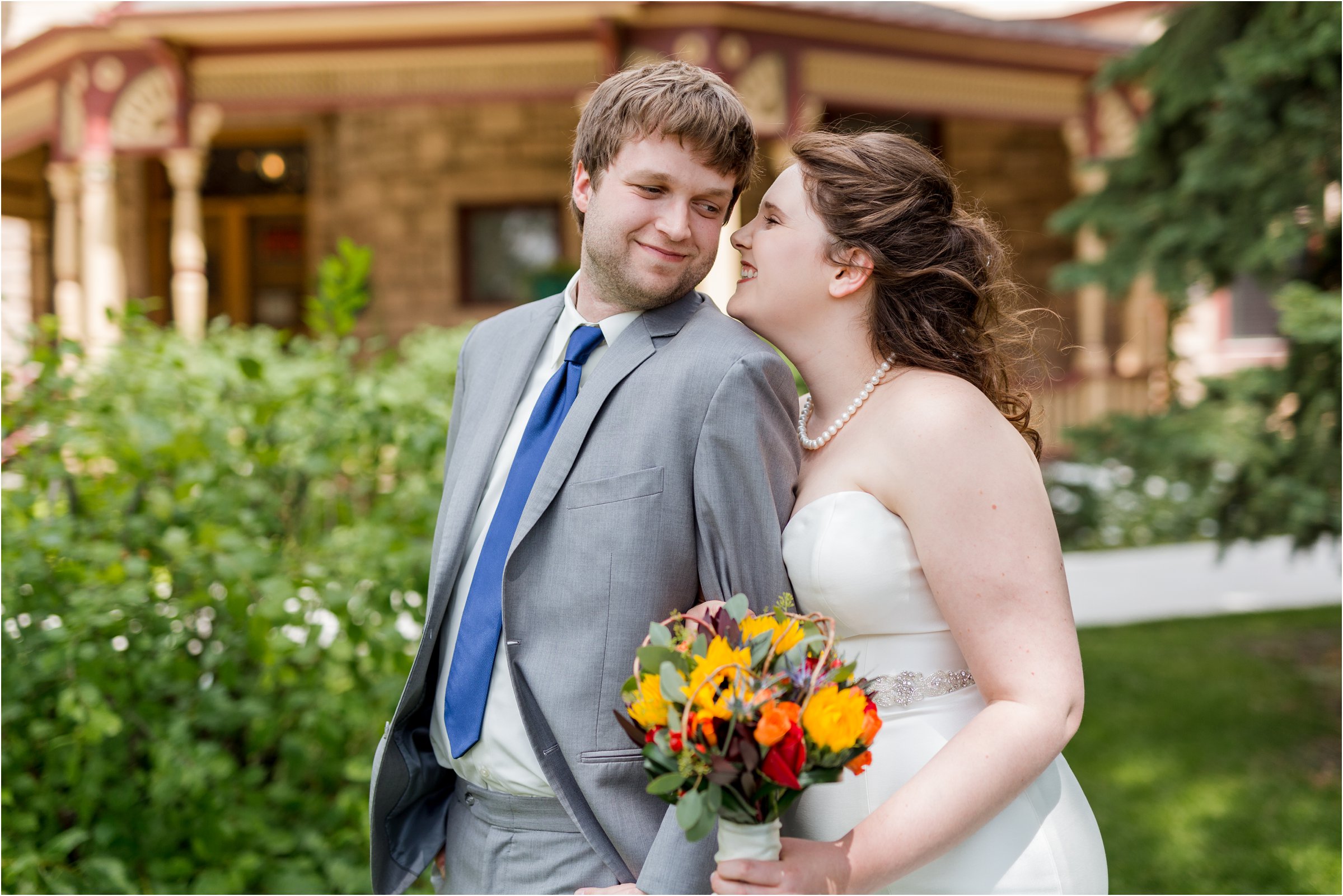 bride and groom pose for a photo in front of the ivinson mansion in laramie