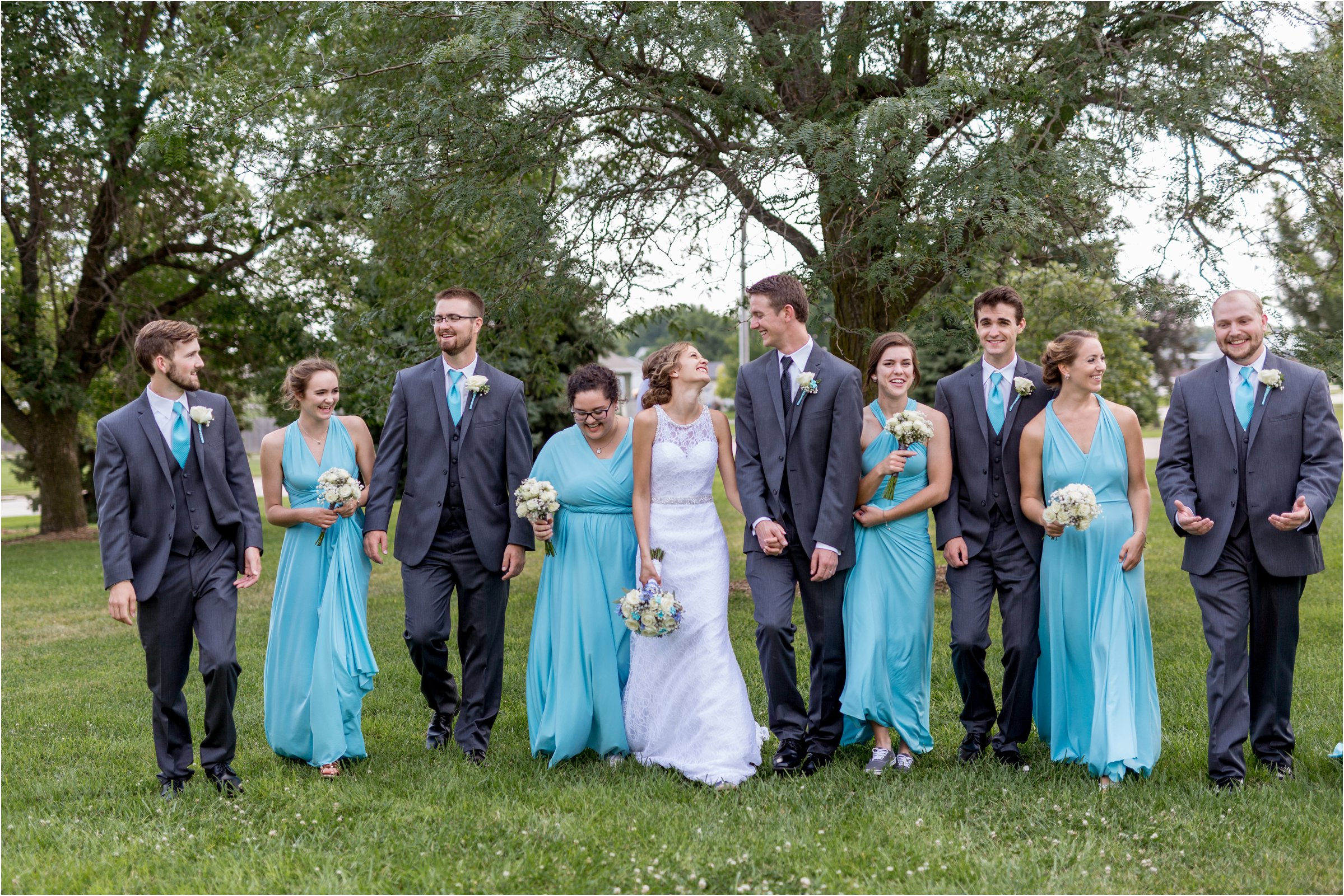 bride and groom walk with their bridal party toward the camera