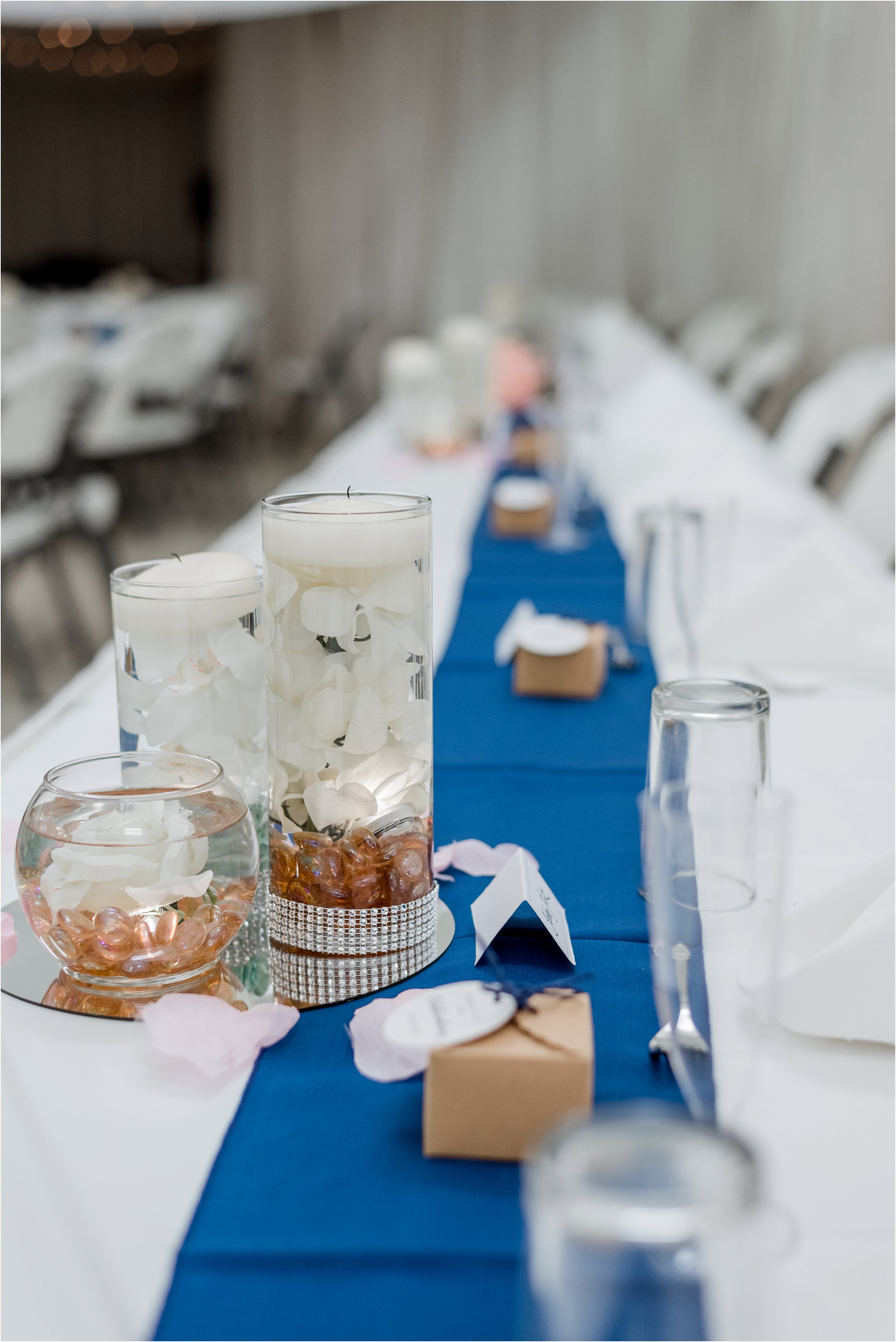 shot of the head table showing off blue table runner and floating candle centerpieces
