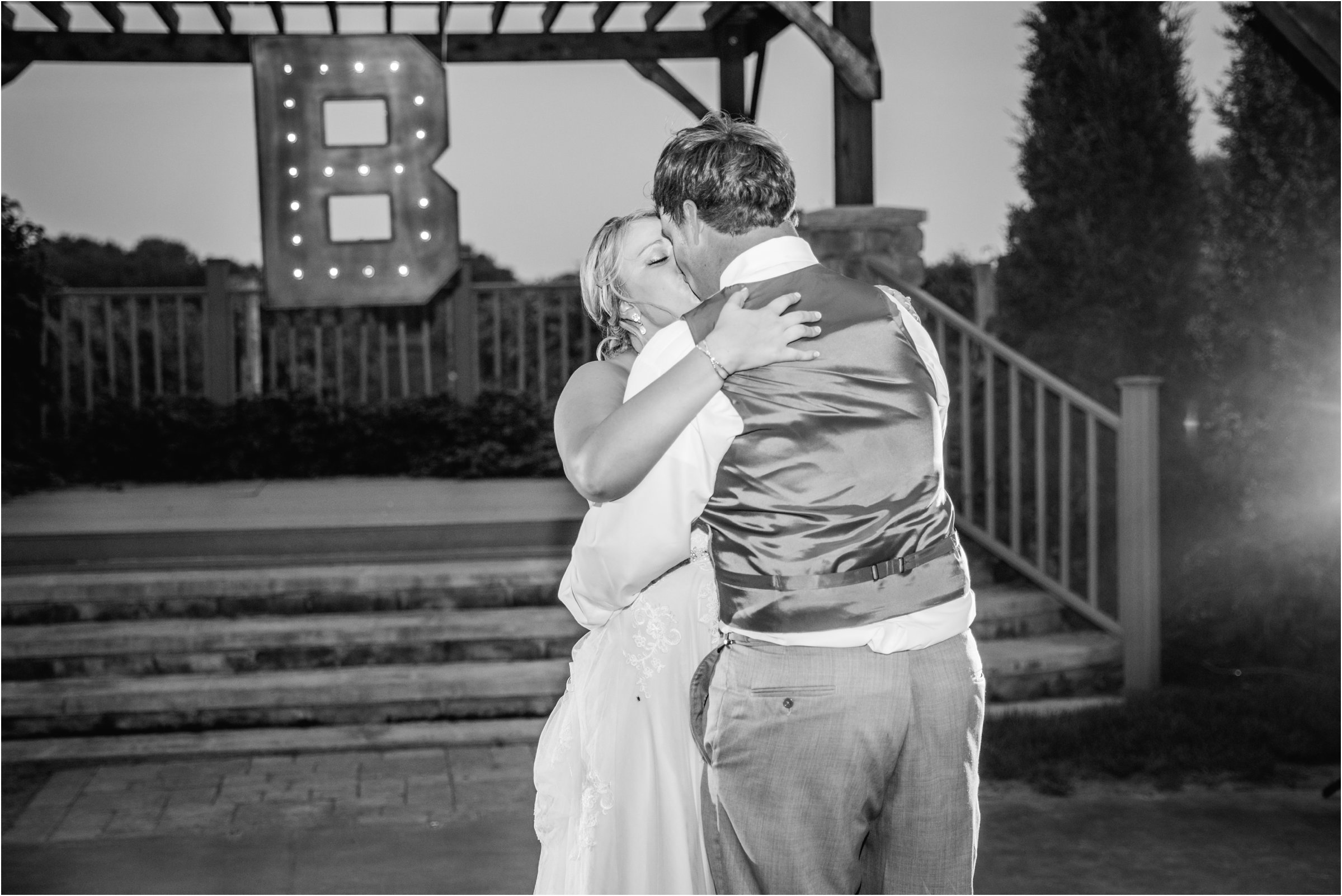bride and groom kiss at the end of their first dance as husband and wife during their wedding reception