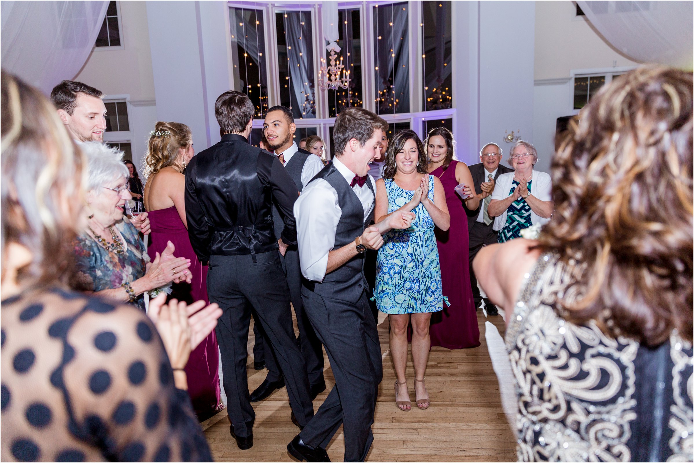 guests dance at wedding as bride and groom dance together