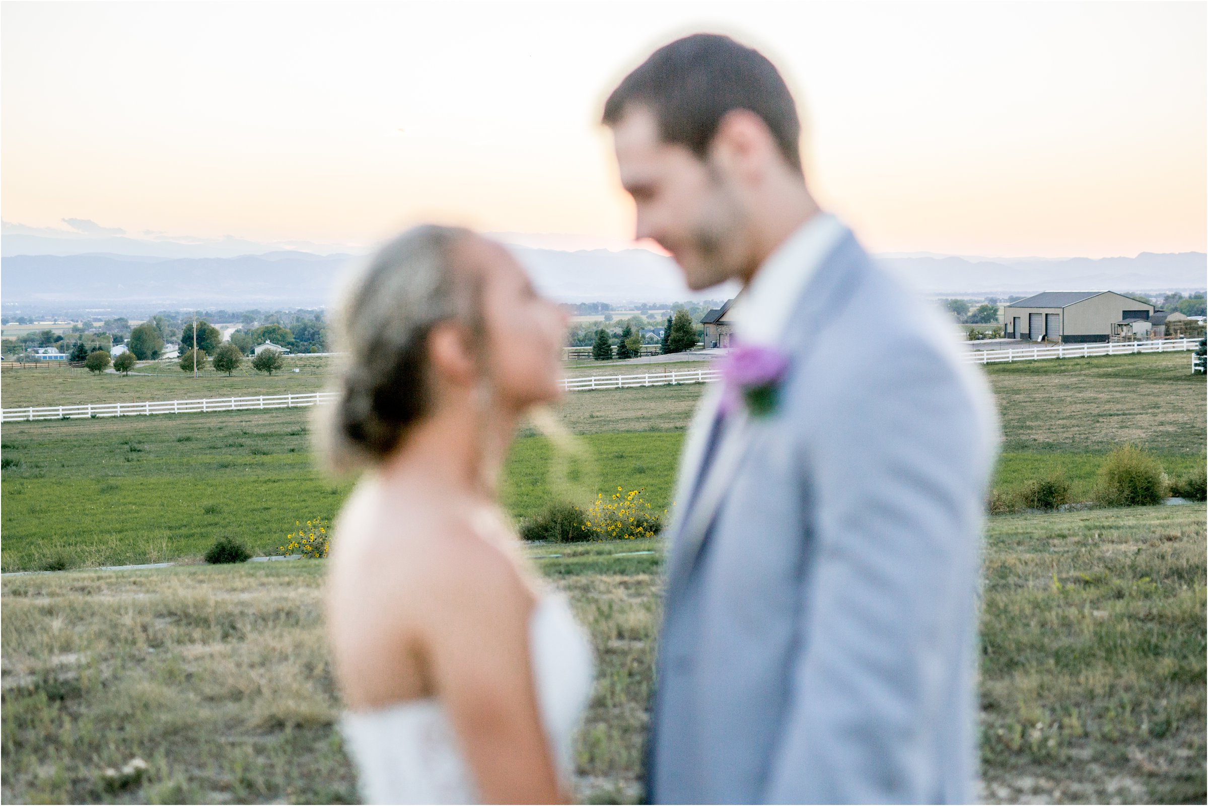bride and groom out of focus with mountain range in background