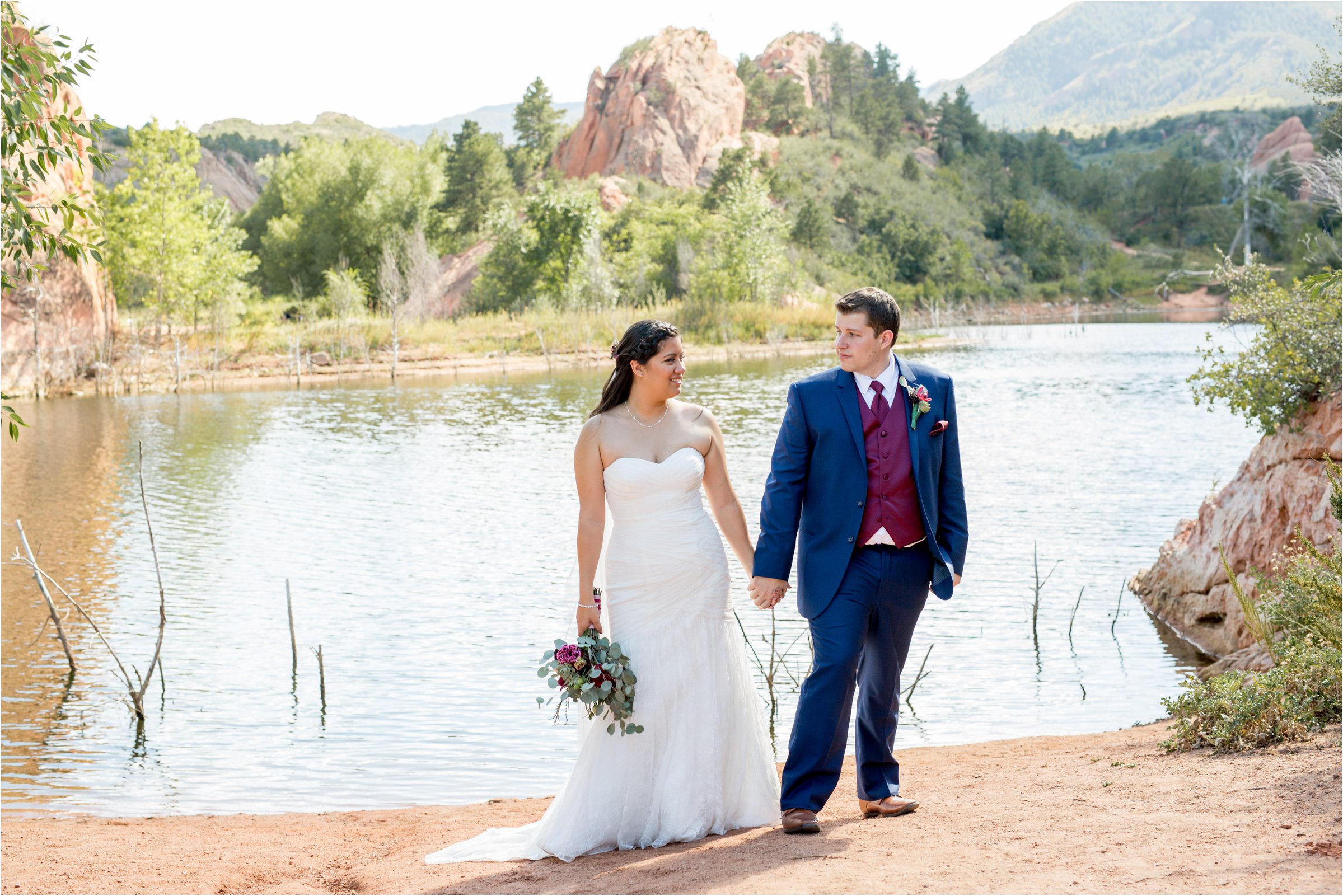 Bride and groom stand side by side in front of a lake in Red Rock Canyon Open Space