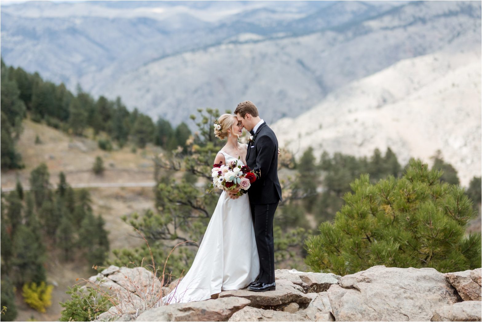 Couple stands on rock overlooking mountains for boettcher mansion wedding