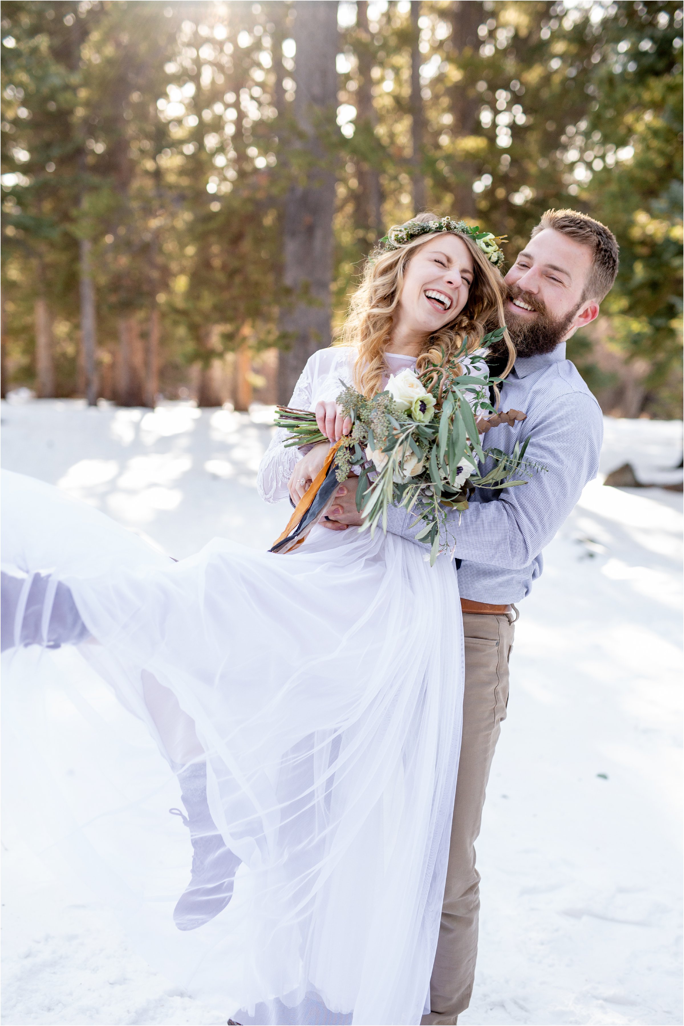 Groom and bride laughing as groom swings bride around playfully in mountain elopement near Denver