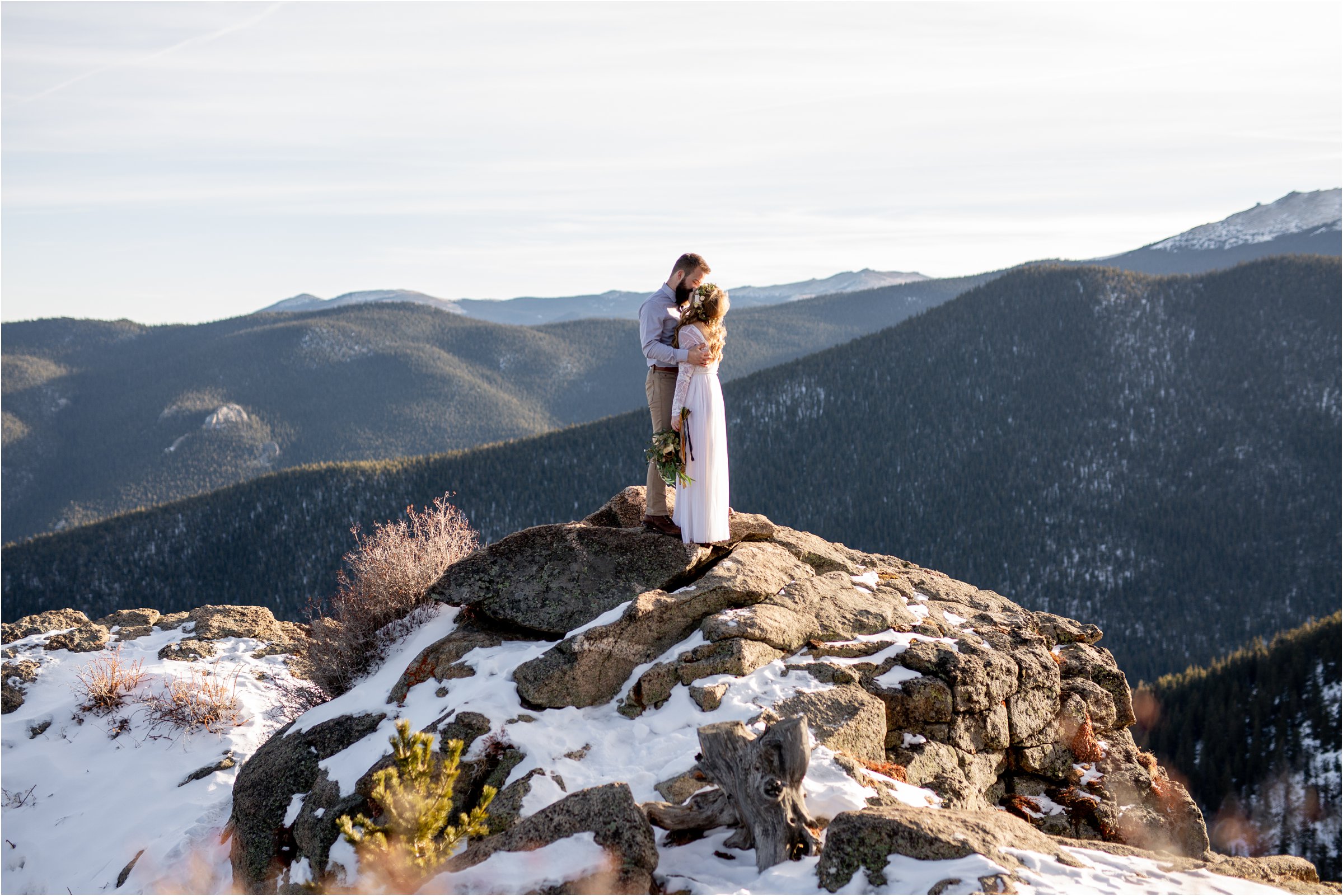 Bride and groom snuggling on mountain top with large bouquet and flower crown for their Denver elopement