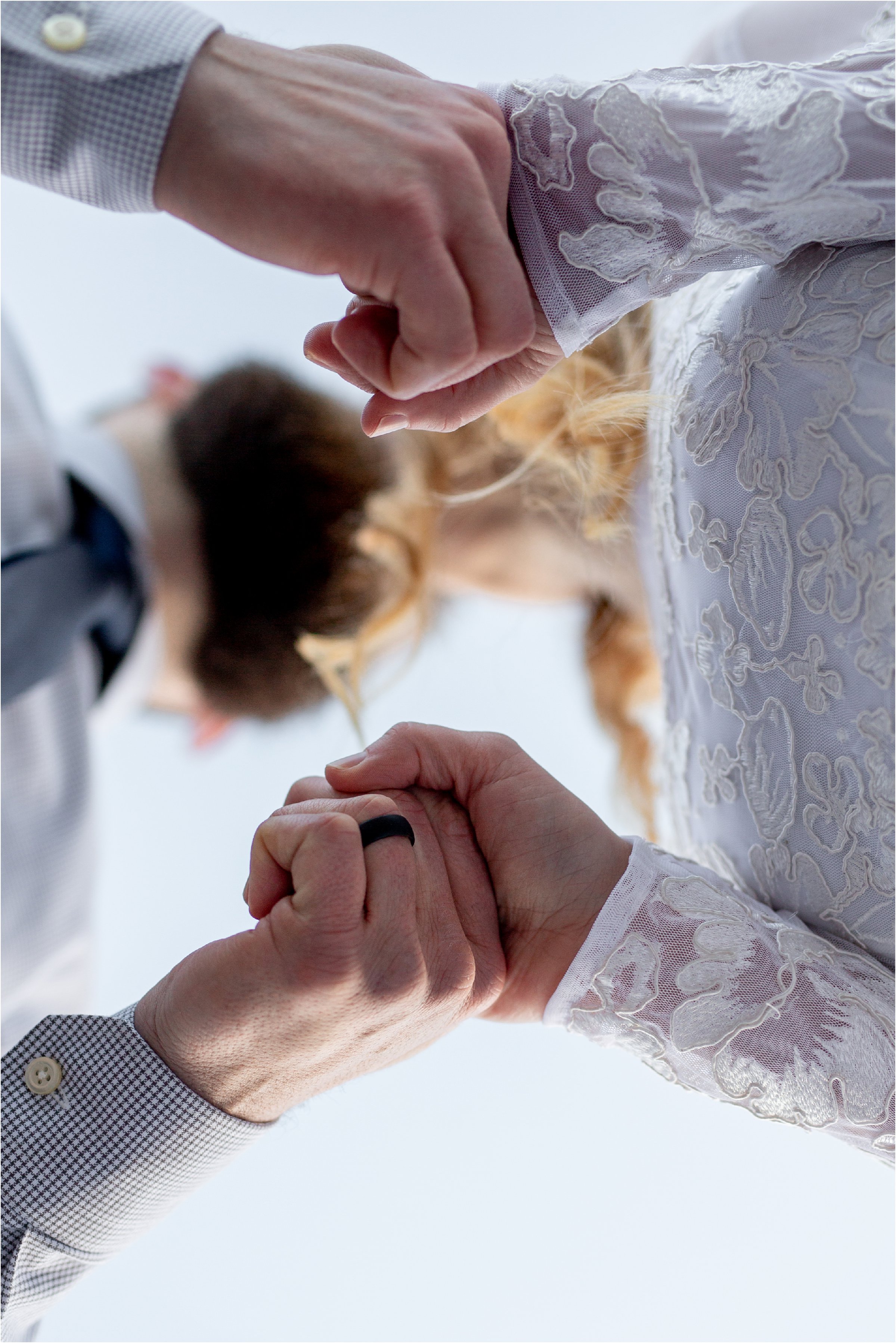 Couple in wedding attire holding hands and kissing during Denver Elopement