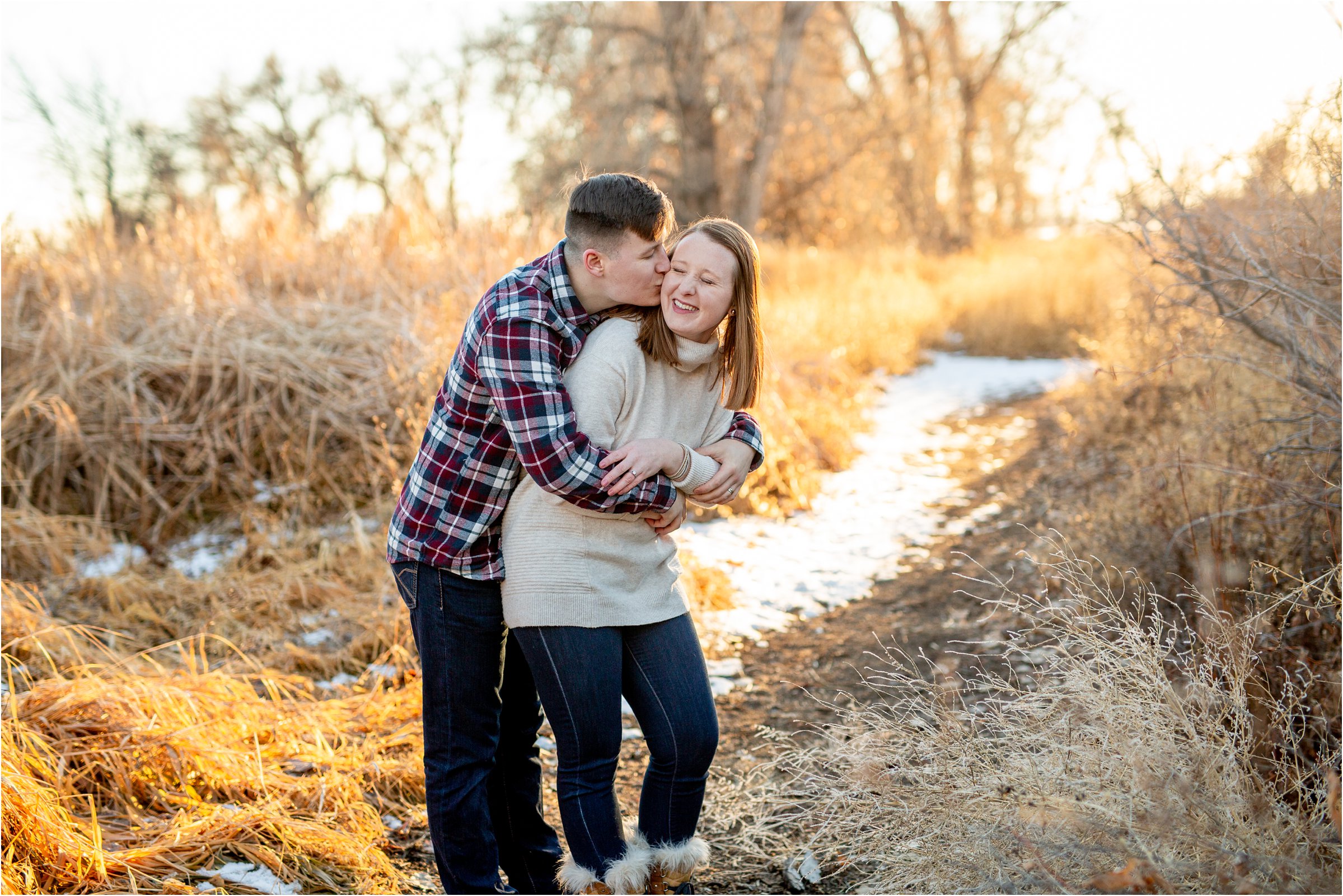 husband kissing wife on the cheeck while she laughs in their denver anniversary session