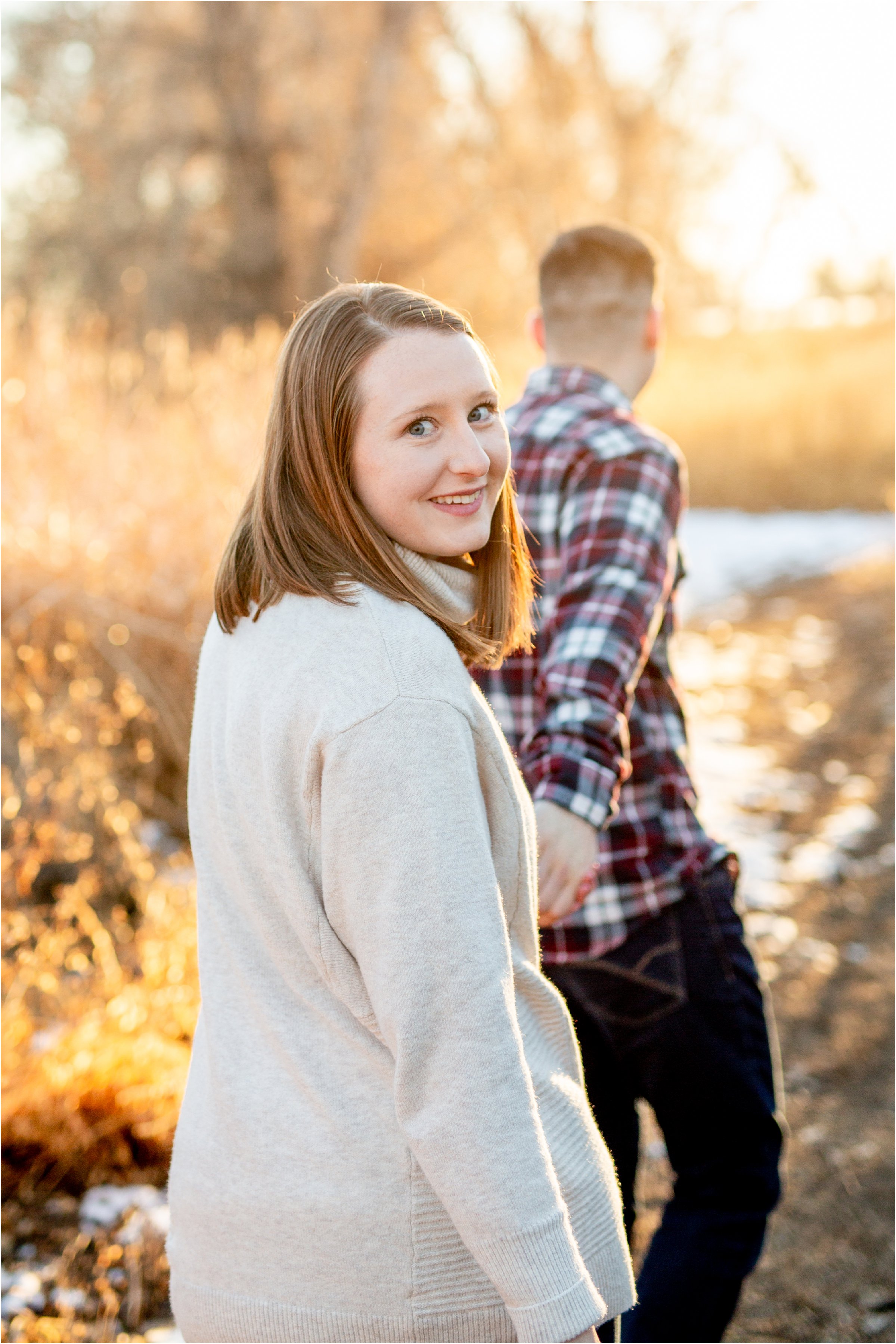 husband leading wife away as she looks back at camera in their denver anniversary session