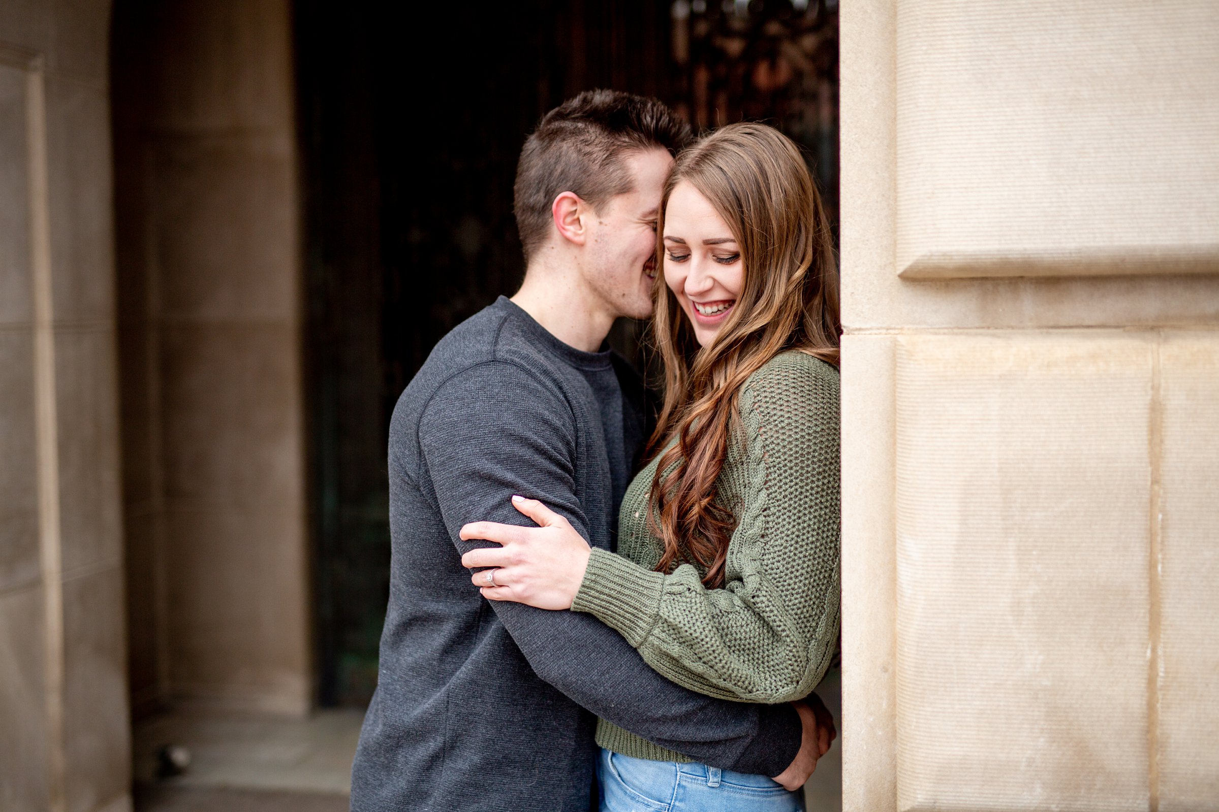 engaged couple snuggling next to a wall for their fort collins engagement session