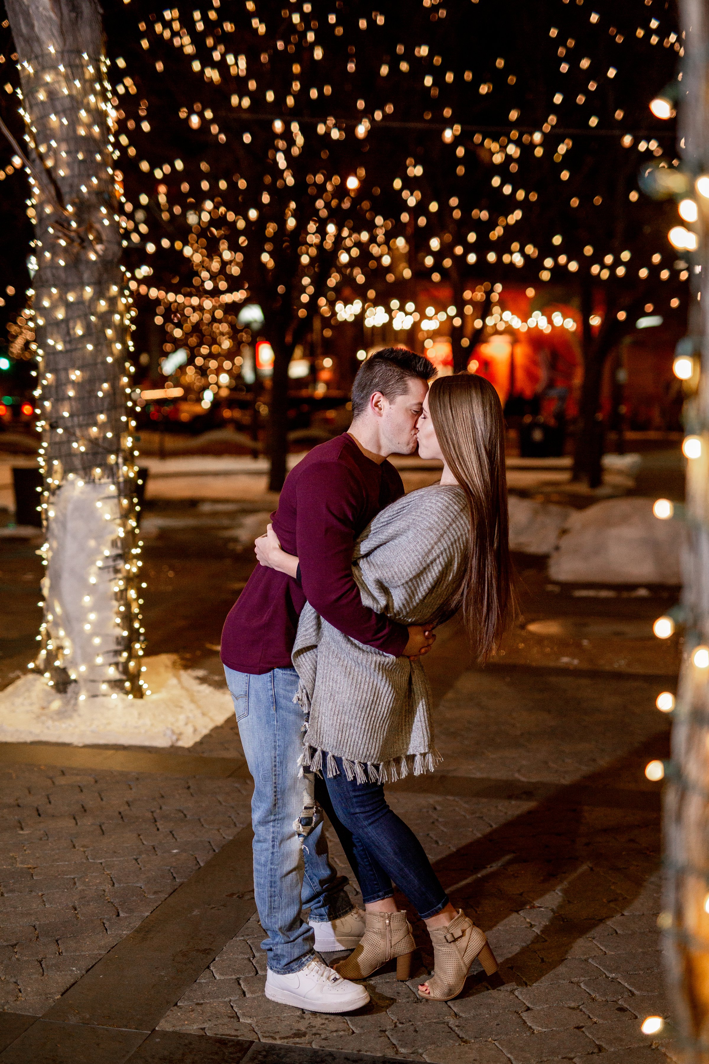 Engaged couple in downtown fort collins lights at night with snow on ground