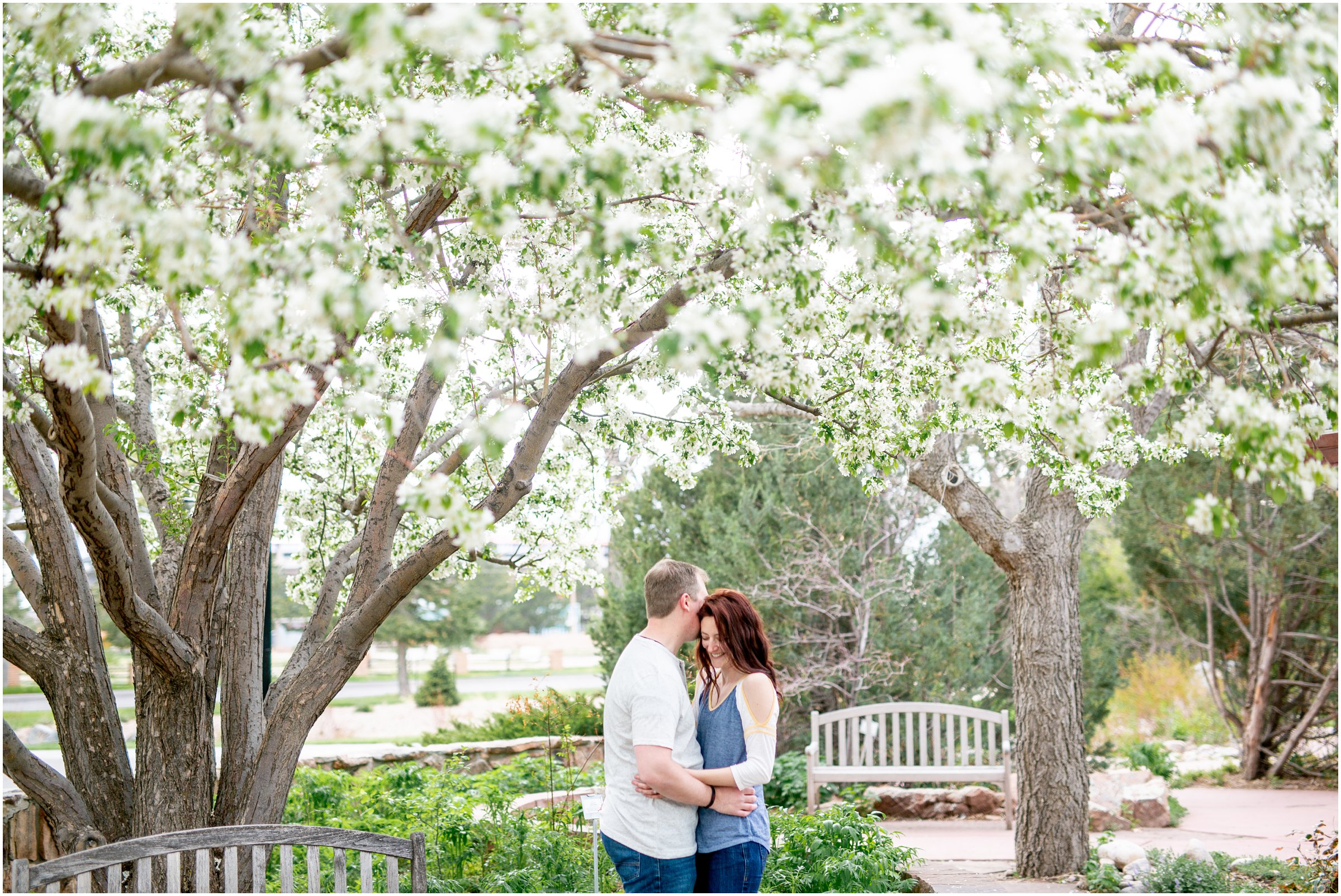 Engagement Session in Cheyenne Wyoming at Lions Park. Baseball themed with lots of flowers and blooming trees. 