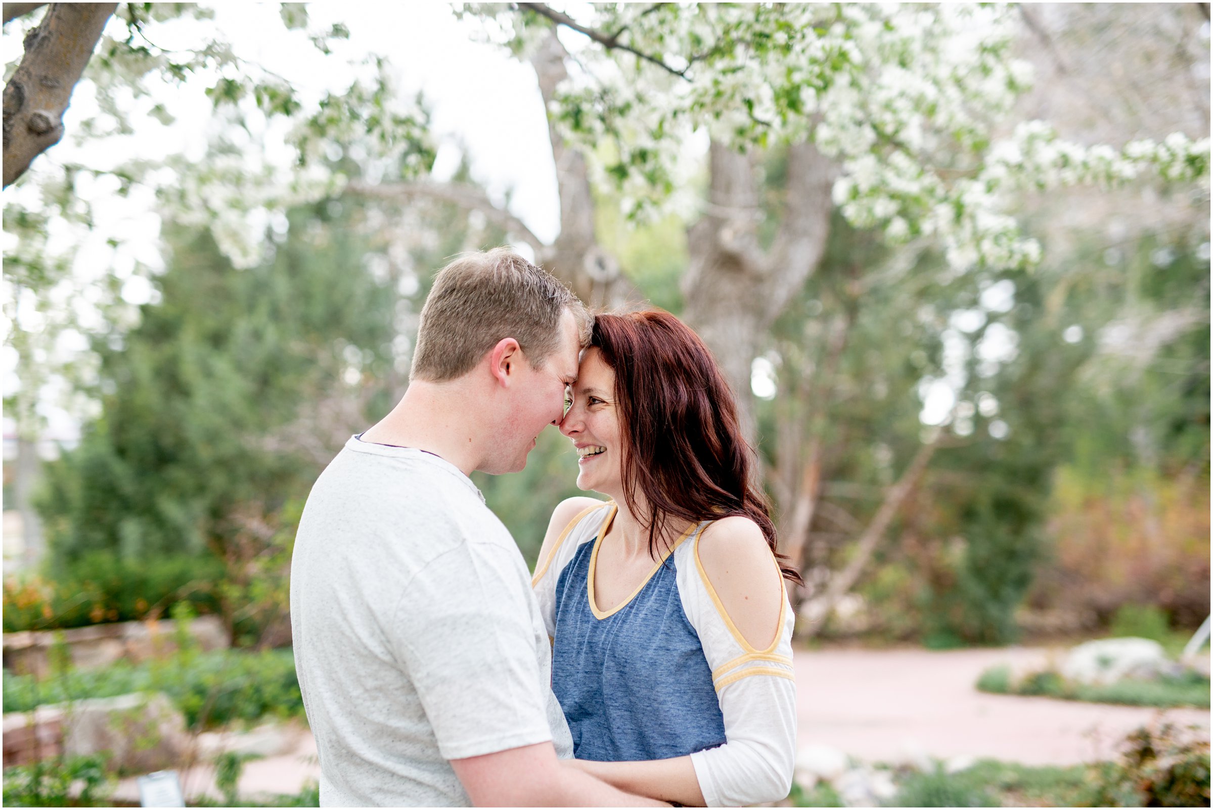 Engagement Session in Cheyenne Wyoming at Lions Park. Baseball themed with lots of flowers and blooming trees. 