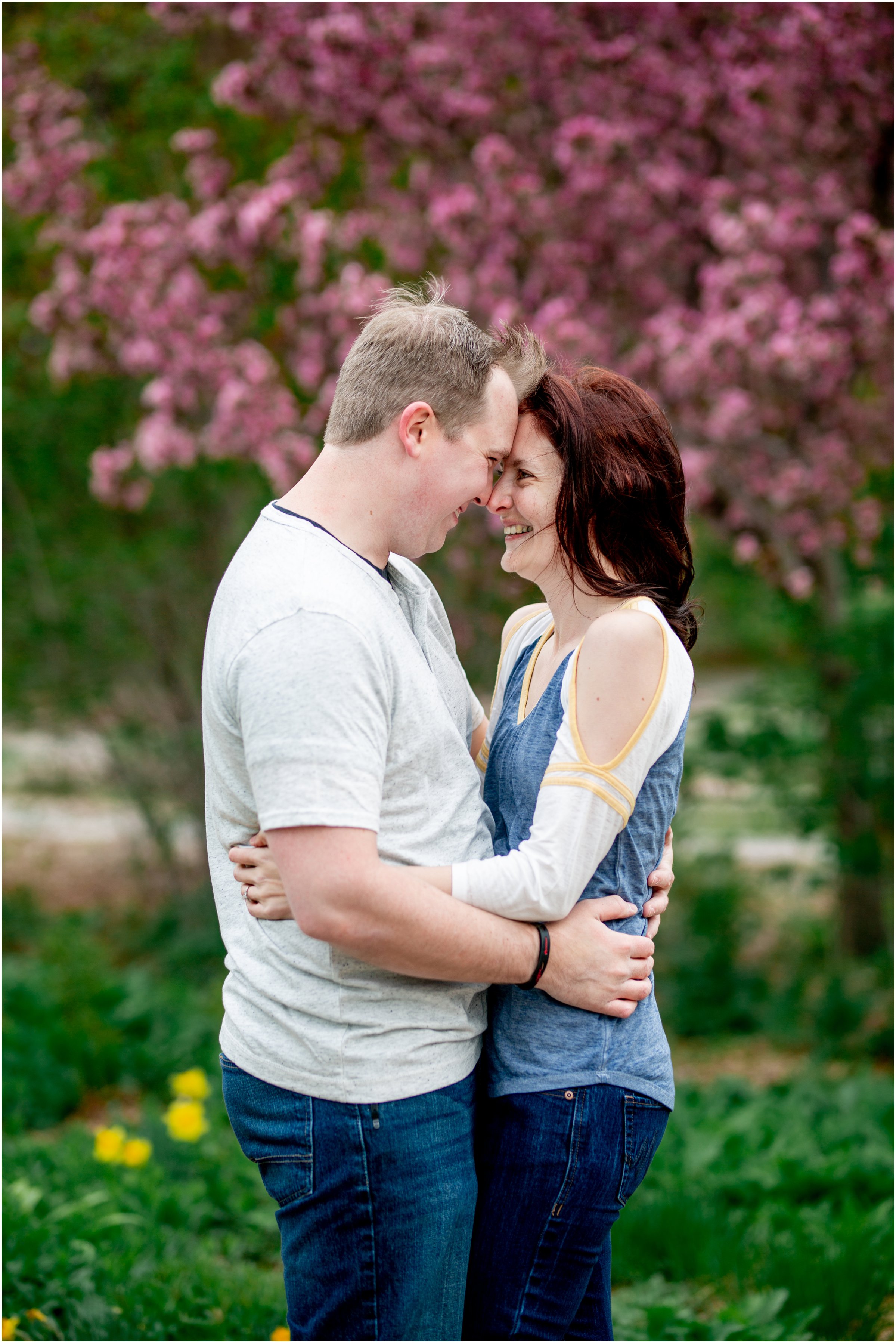 Engagement Session in Cheyenne Wyoming at Lions Park. Baseball themed with lots of flowers and blooming trees. 